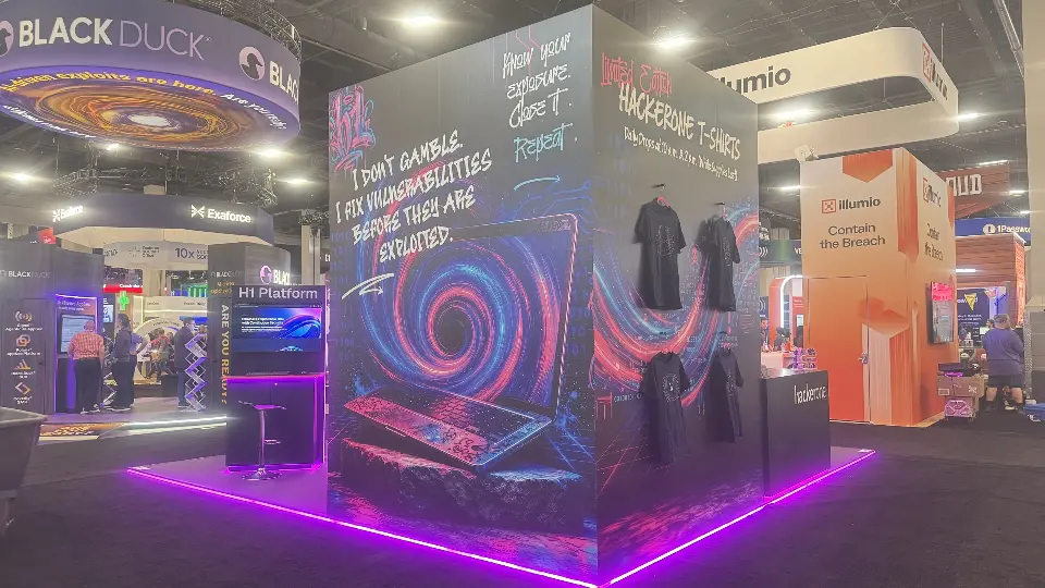 Side wall with handwritten-style slogans and hanging T-shirts above a magenta lit base