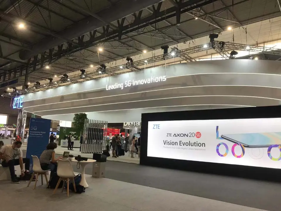 Lounge tables beside a screen showing the Vision Evolution campaign