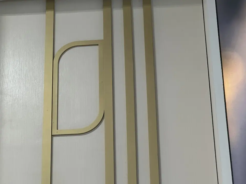Finished close-up of a gold line inlay curving across a white panel