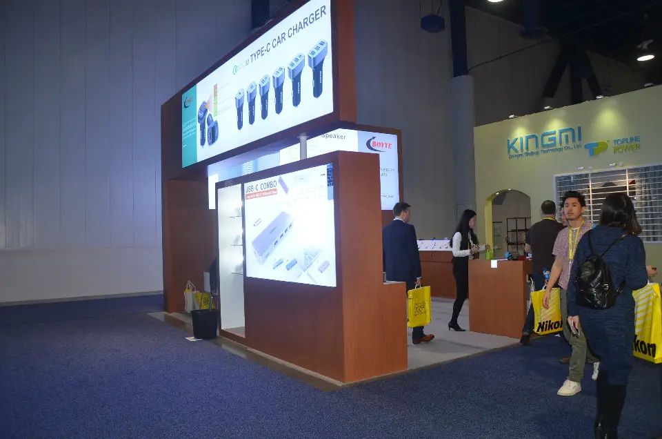 Corner shelving and earphone lightbox with attendees passing by
