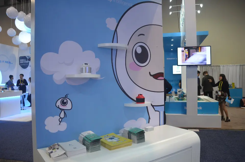 Wall graphic with a cartoon robot face, cloud shelves and a display counter