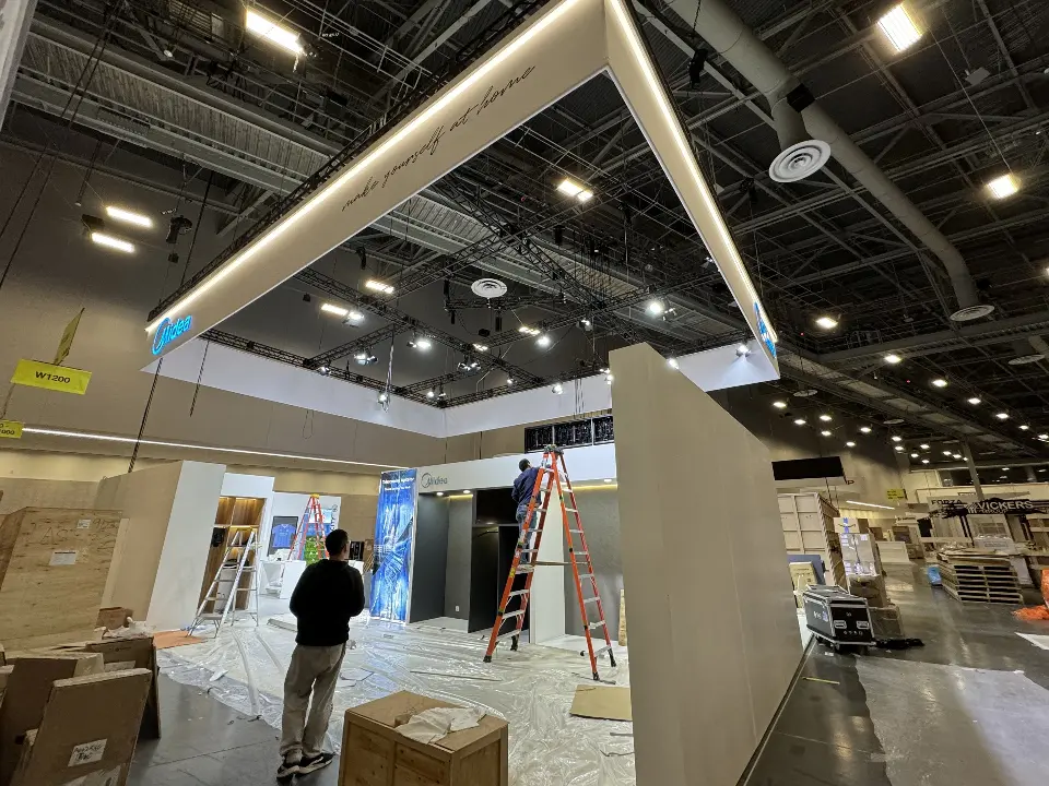 During installation: tall white wall section with a ladder and a worker beside it