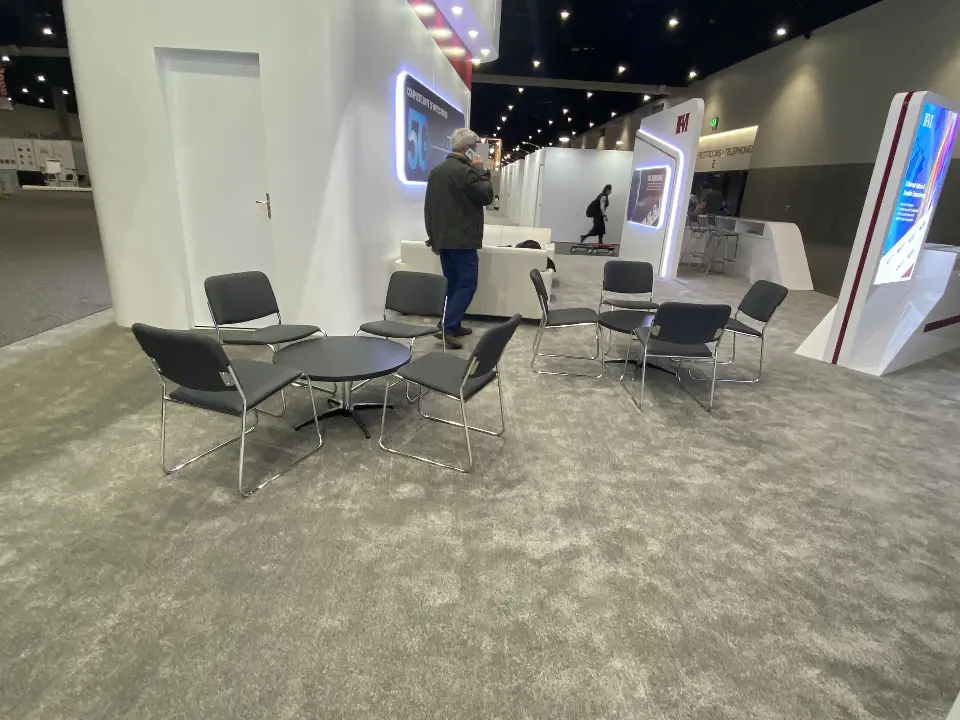 Lounge with dark chairs and a round table on grey carpet
