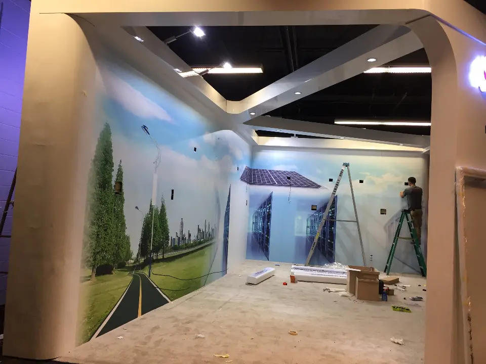 During installation: arched white frame and landscape mural with a ladder inside the booth