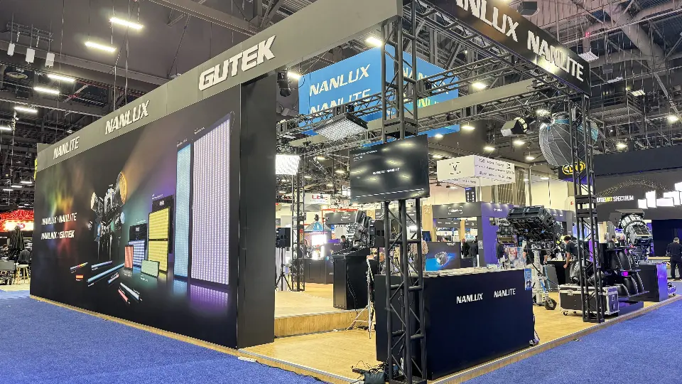 Corner of the stand showing the dark Gutek fascia, black truss and a counter below hanging lights