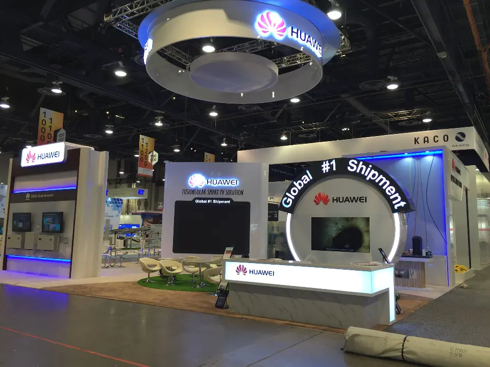 Booth front with plants along the lit counter base and the ring overhead