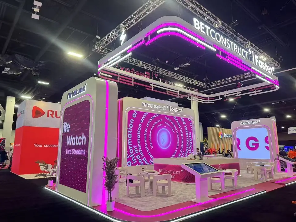 Pink video screens and seating area under the lit overhead ring