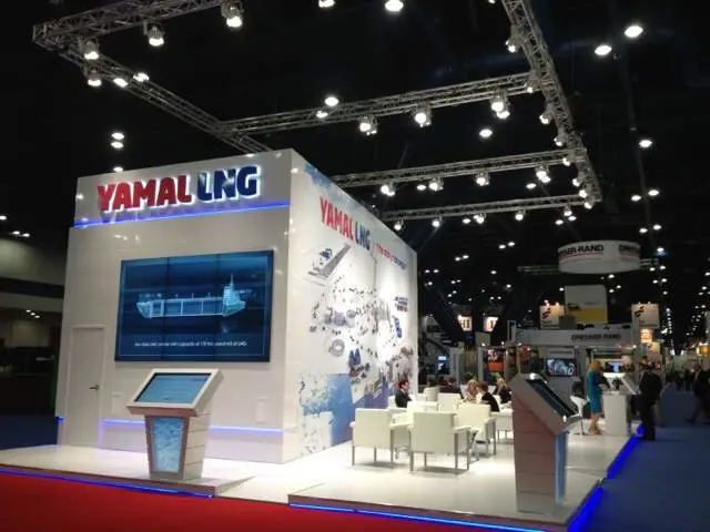 Closer view of the video wall, touchscreen kiosk and white lounge chairs