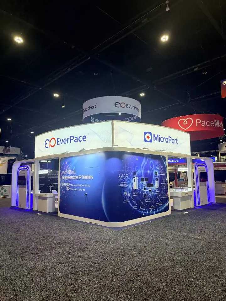 Distant corner view of the booth with lit header and round hanging sign