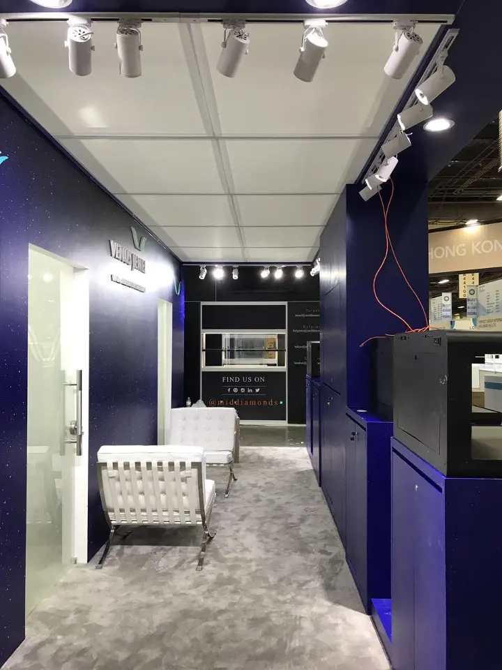 Inner corridor with track spotlights, white lounge chair and navy walls