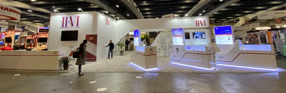 Long panoramic view across the II-VI booth with screens and display counters