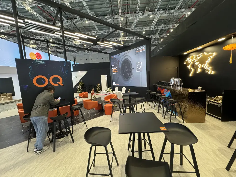 Seating area with OQ wall graphic, video screen and glowing world-map wall