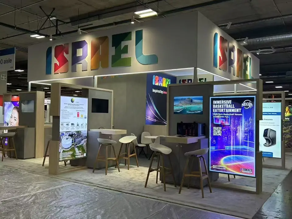 Israel Pavilion corner with backlit company panels, video screens and lounge seating