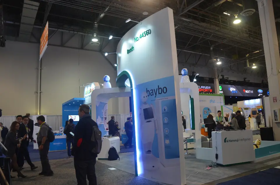 Side view of the teal-edged portal and robot display wall near the aisle