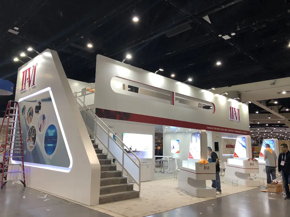 Staircase and graphic frame with crew working beside the booth