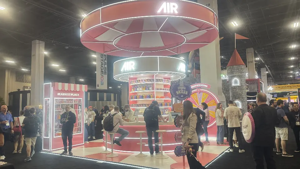 Wider view of the AIR booth with crowds and the carnival canopy