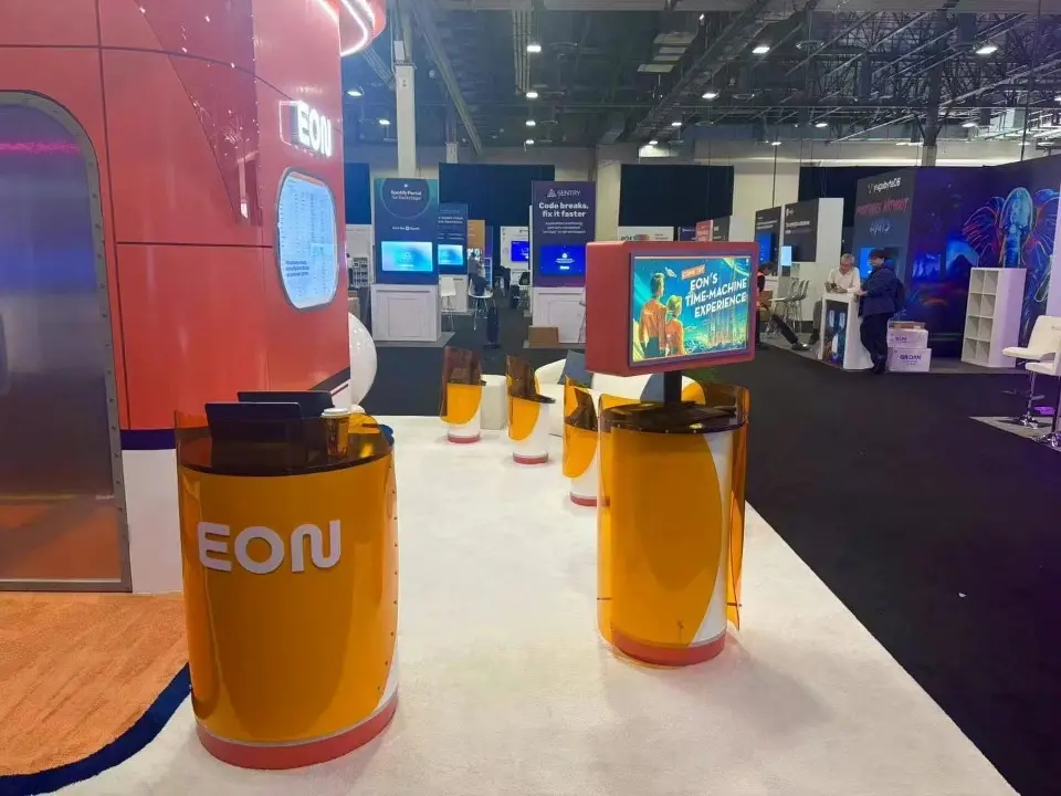 Orange cylinder counters along the white floor with a kiosk screen