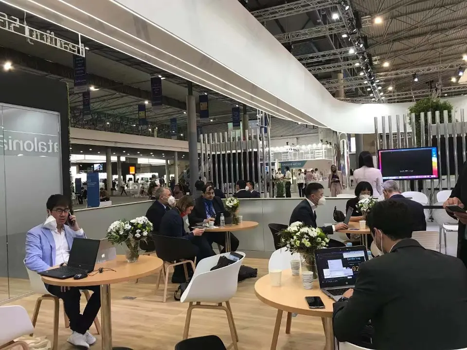 Guests working on laptops at small round tables in the lounge area
