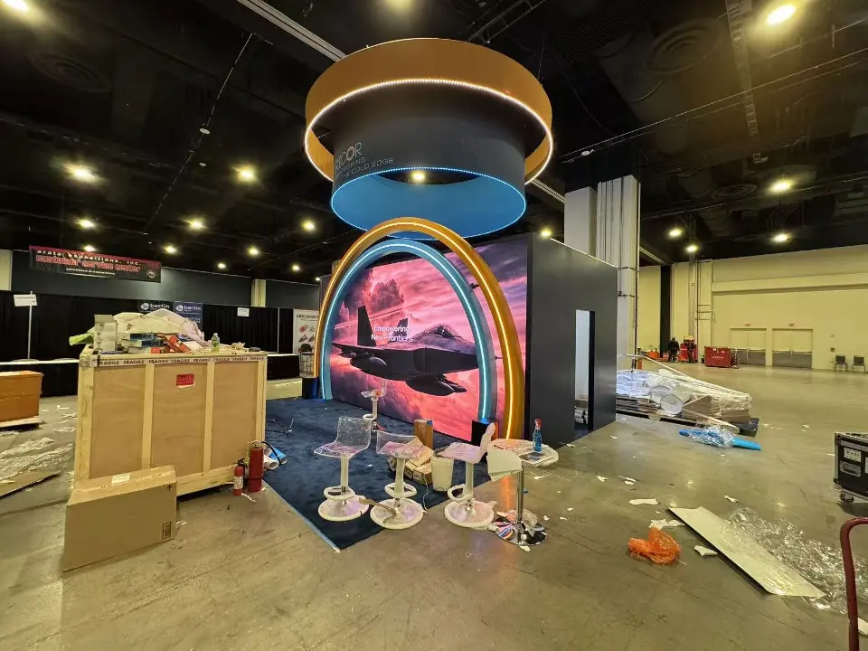 During build-up: lit orange and blue arches framing a jet graphic under the ring sign