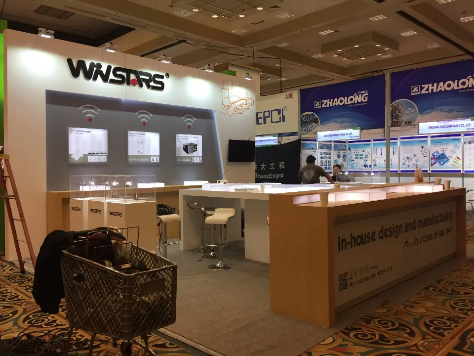 WNSTARS booth with wood-look counters, white back wall and three backlit product panels