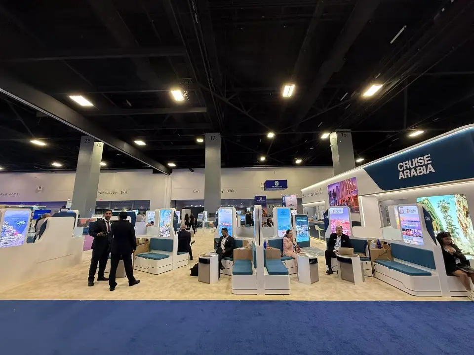 Long side of the Cruise Arabia booth with teal pods and lit header edge