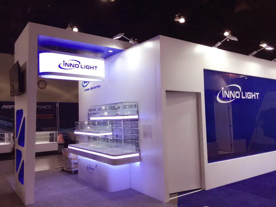 White tower with InnoLight logo beside lit glass shelves
