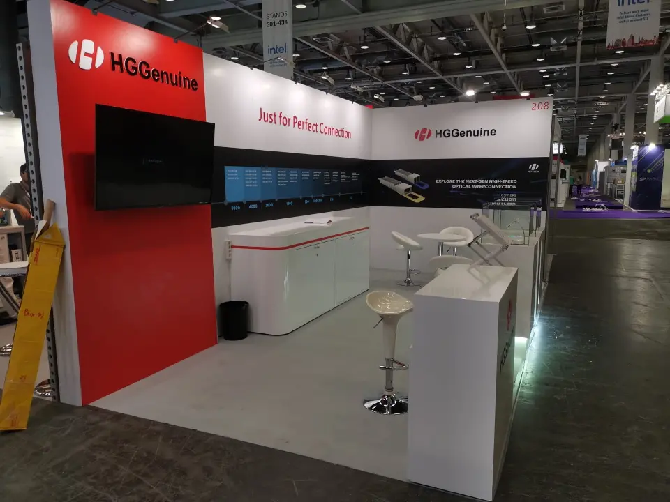 HGGenuine booth 208 with red logo wall, video screen, speed-range graphic and lit glass showcase