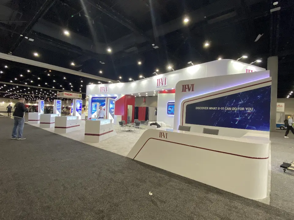 Front of the booth with white counter and demo kiosks