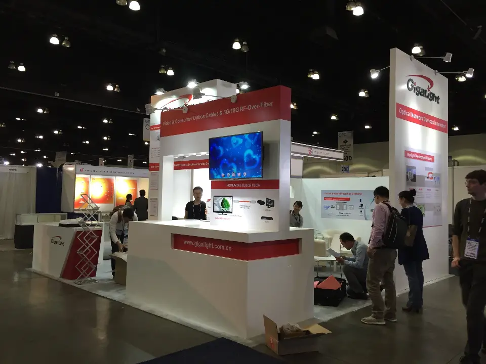 Visitors at the Gigalight booth with screen wall, counters and tower graphics
