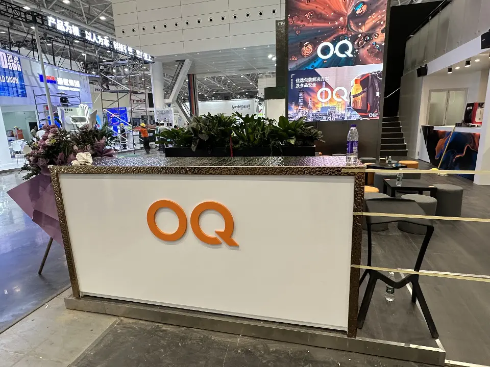 White OQ reception counter with plants and stairs visible behind