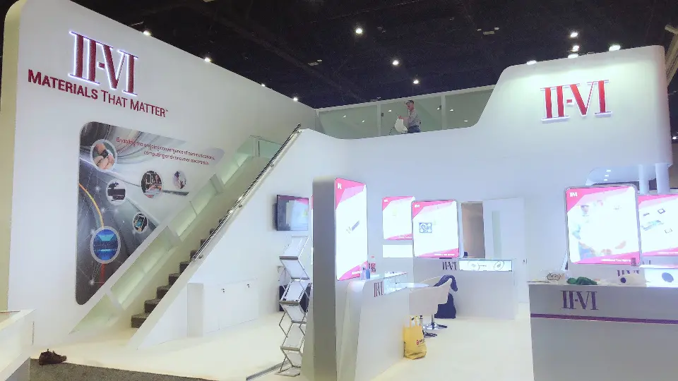 Staircase beside backlit pink product graphics and a white display table