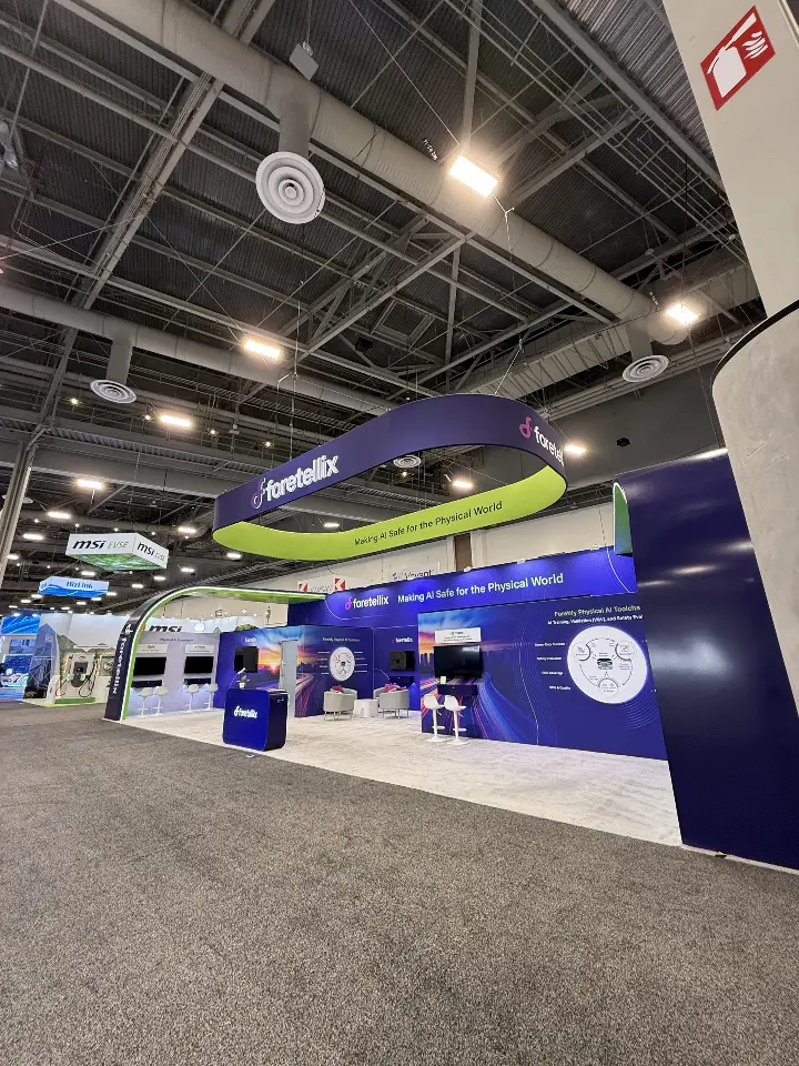 Wide low-angle aisle view of the navy and lime-green island booth under hall lighting