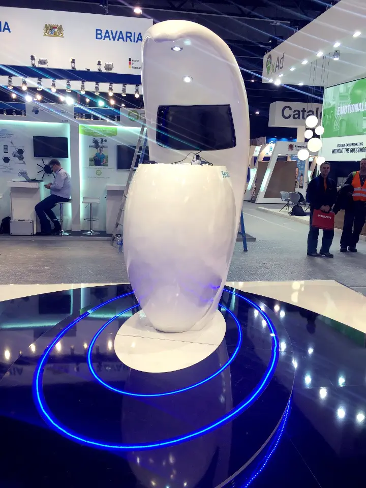 Tall white pod chair with a curved hood standing on a blue-lit base