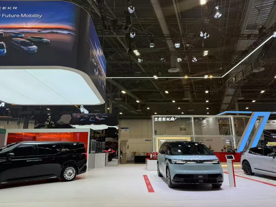 Two vehicles on the light display floor with the curved screen edge above