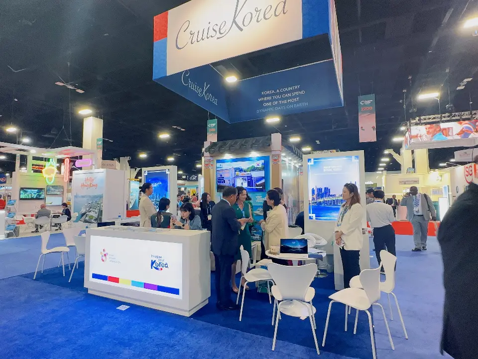 Wide view of Cruise Korea booth with traditional roof pavilion, Busan lightbox and white meeting chairs
