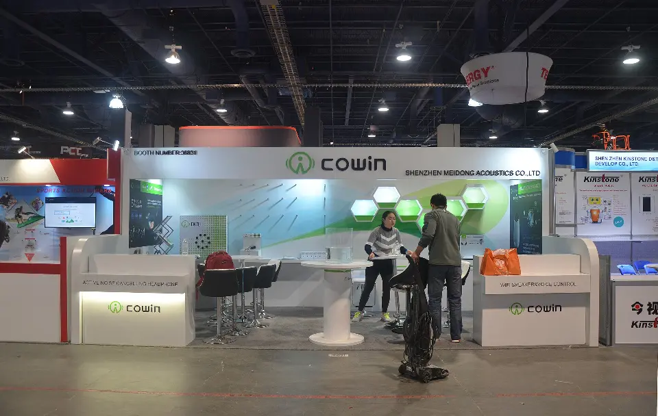 Cowin booth with white counters, lit base strips and green hexagon back wall