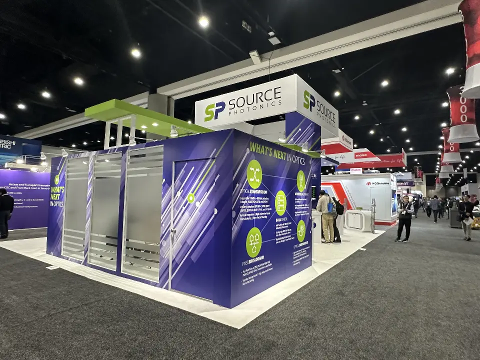 Corner of the booth with purple walls, green graphics and a metal panel