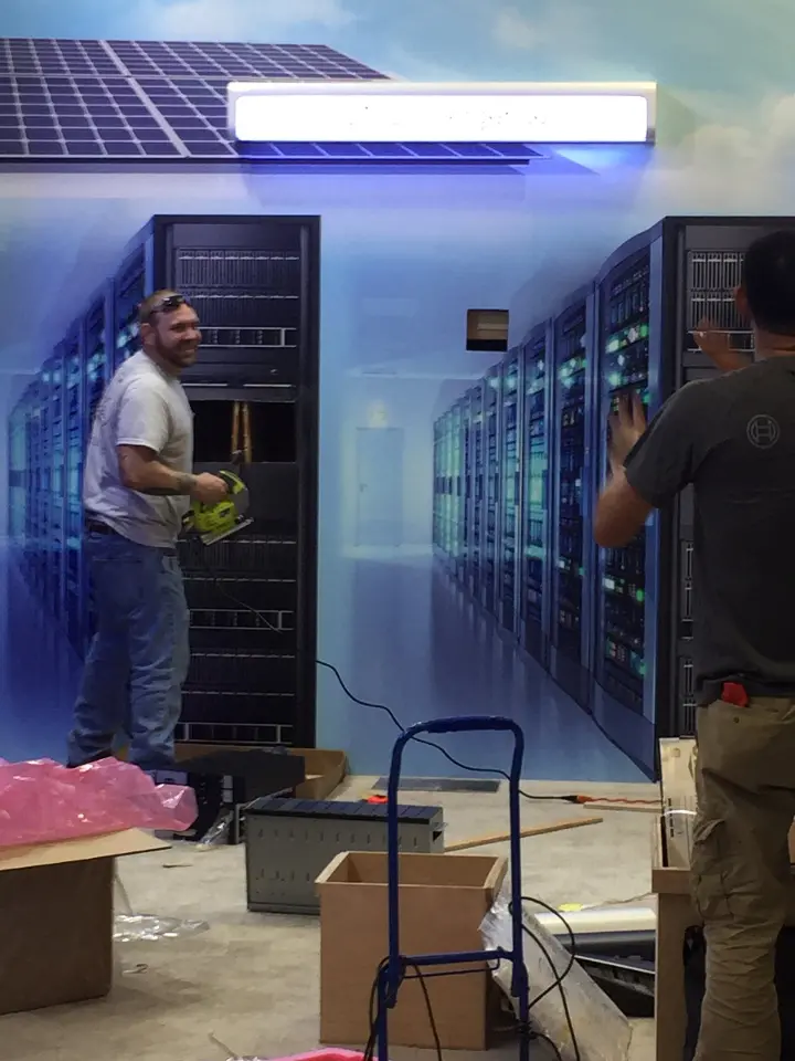 During installation: close shot of a worker at the server cabinet row with boxes nearby