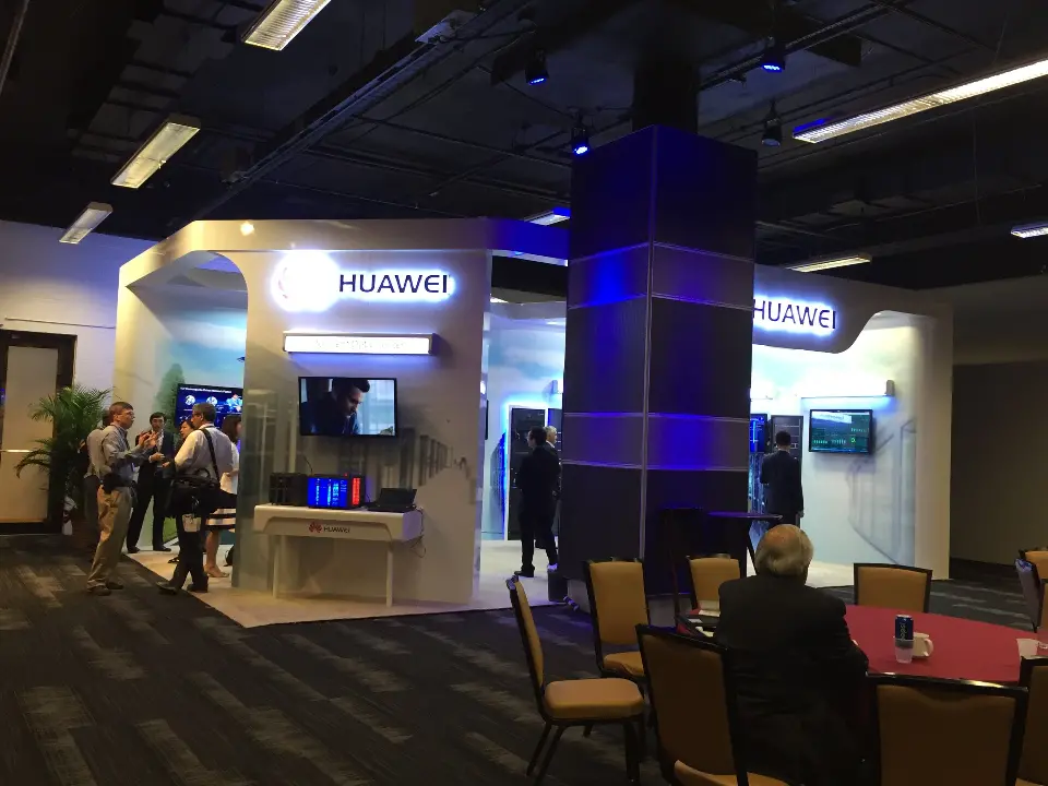Another wide angle of the booth with the column, lit logo and guests at tables
