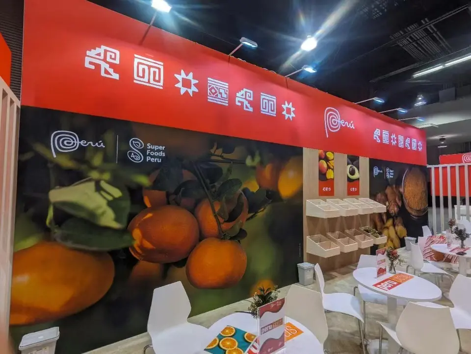 Close view of an orange fruit graphic wall beside white tables and the red fascia