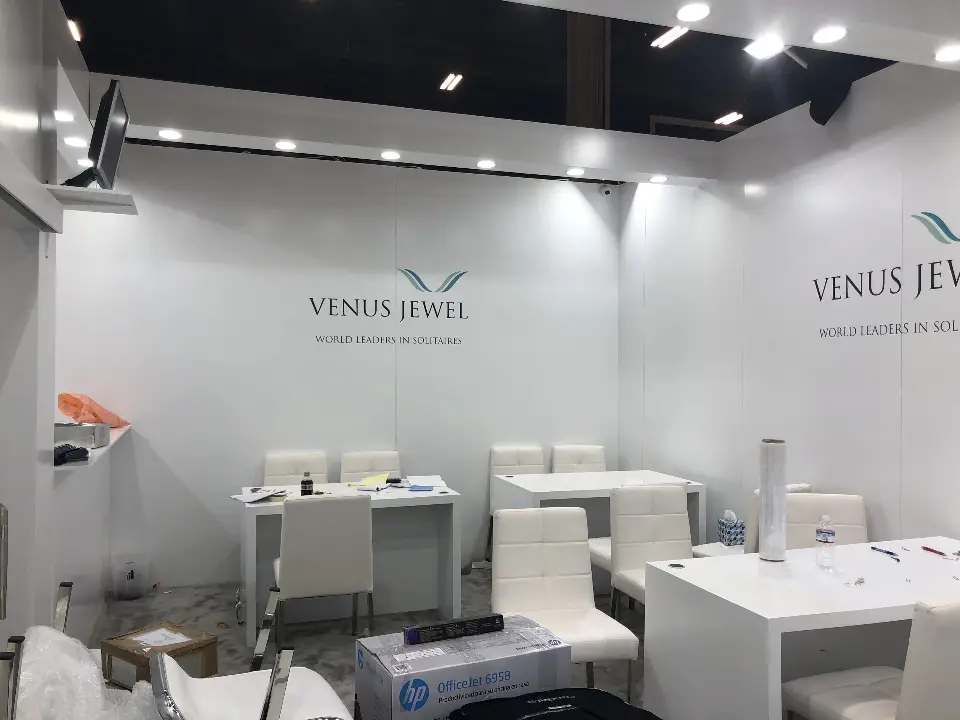 Meeting room seen from the door with white tables and grey logo wall