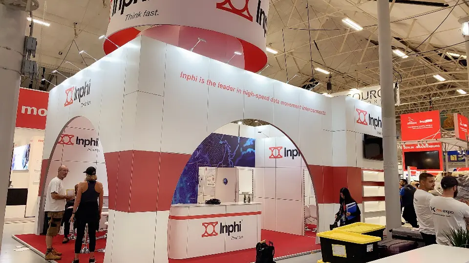 Corner of the Inphi booth with red arch entrance, logo counter and round hanging sign