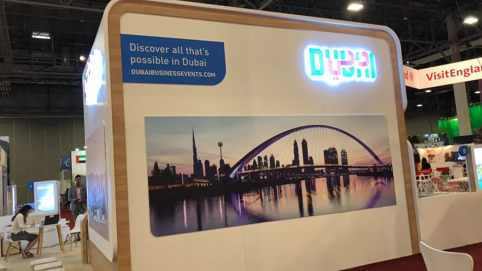 Curved wall with a city bridge graphic and a glowing Dubai logo