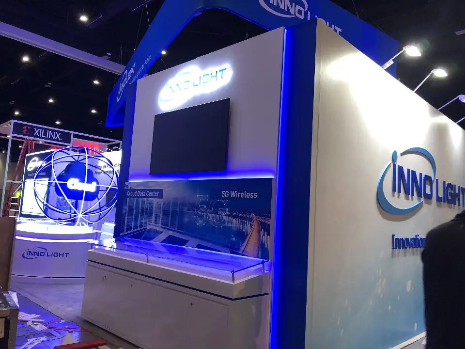 InnoLight booth corner with lit glass counters and blue logo wall