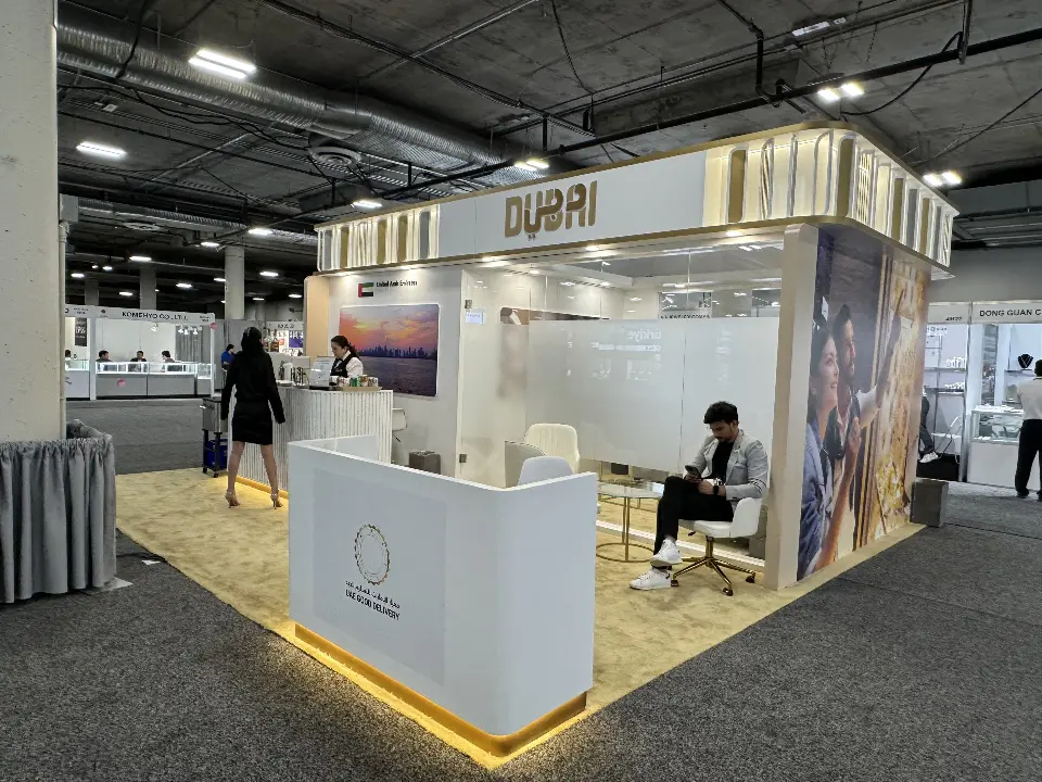 White counter with lit base and lounge area under the gold header