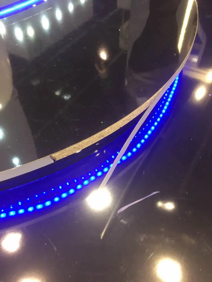 Detail of a blue light strip tracing the curve of the black floor edge