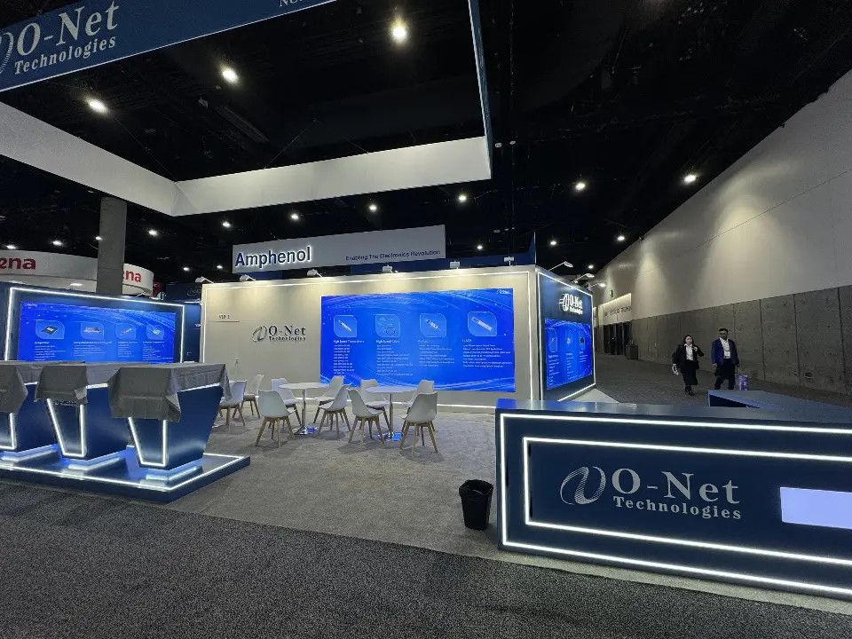 Rear view of O-Net booth with lit counter, demo stands and white seating
