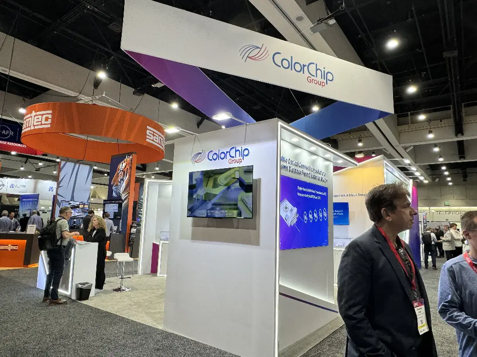 Side wall with screens and the ColorChip sign seen from the busy aisle