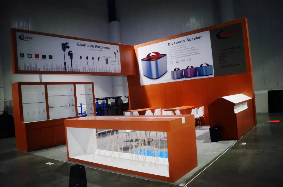 Booth under dim hall light with lightboxes glowing above the shelving