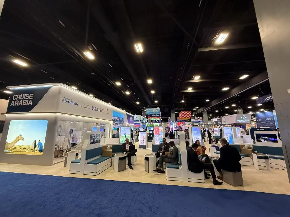Visitors seated in teal pods under the Cruise Arabia corner sign